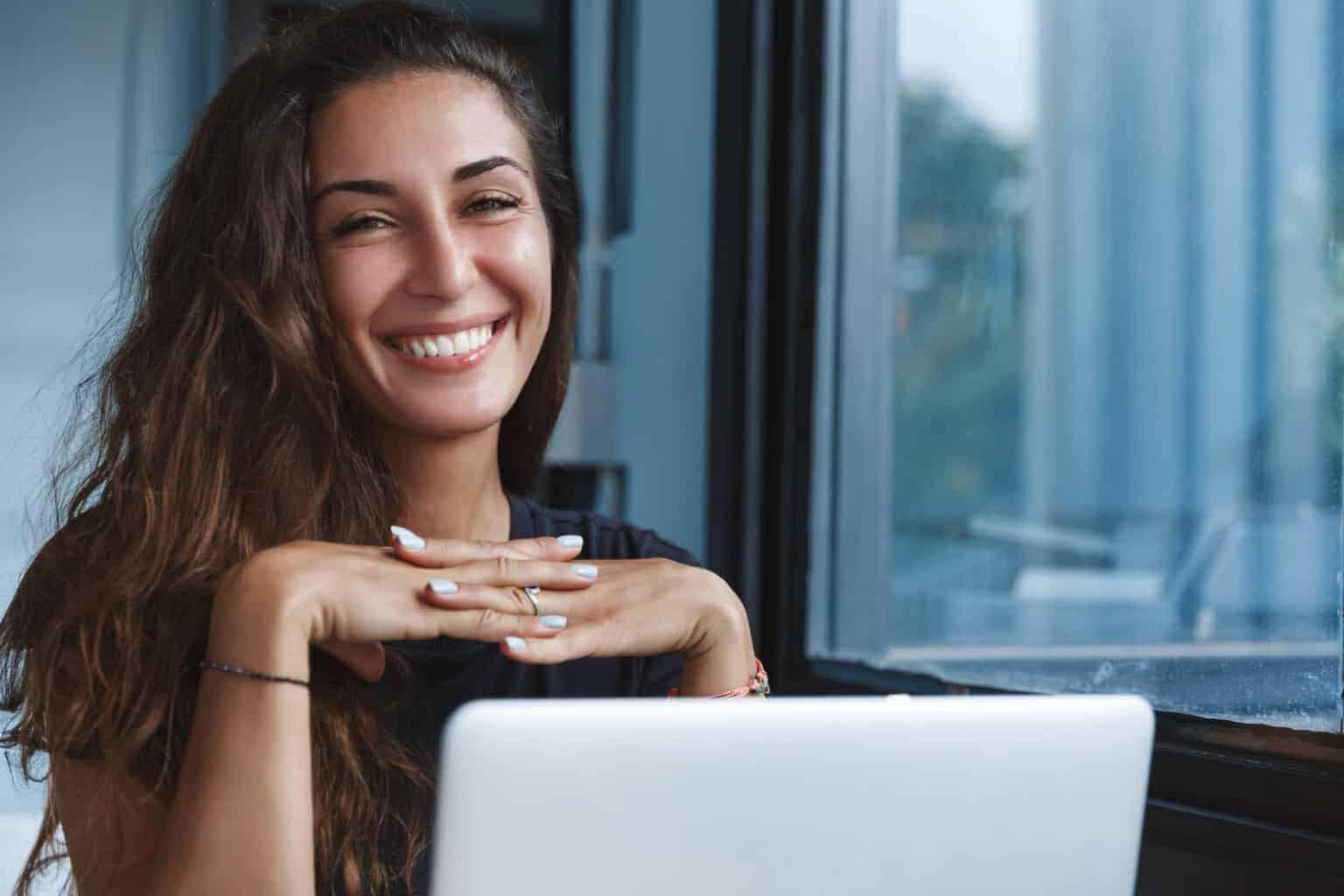 Woman smiling in front of a laptop
